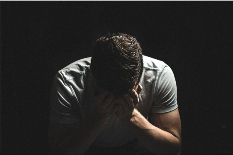 Greiving man with head in hands